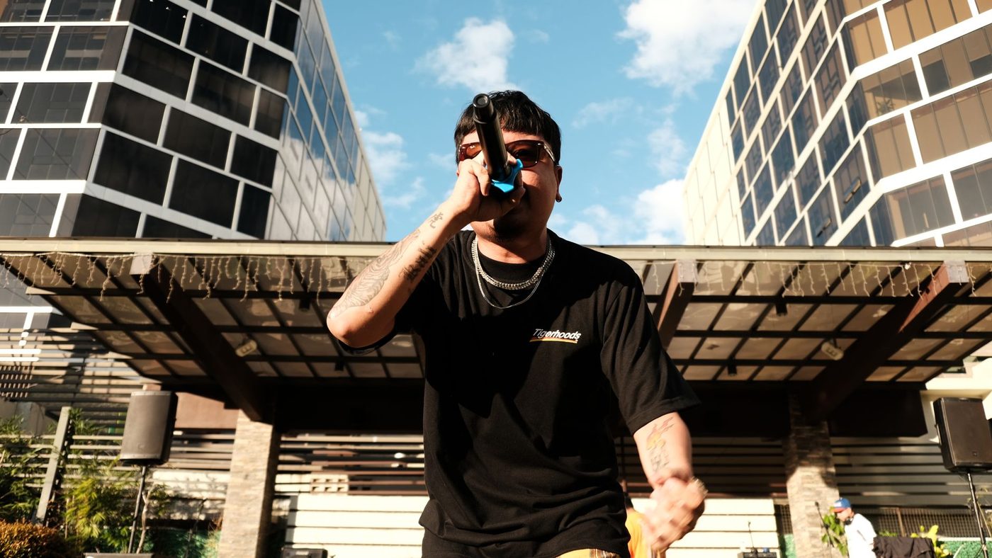 Musician passionately performing outdoors with a microphone in an urban setting. Captivating stage presence.