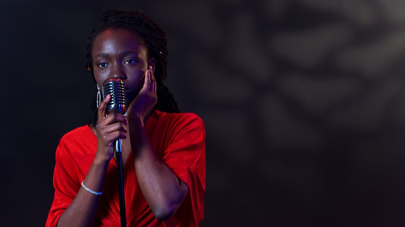 A captivating image of an African American woman singing passionately into a vintage microphone.